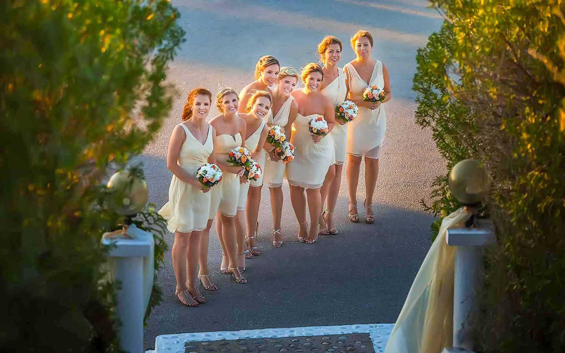 Τhe-Beautiful-Bridesmaids-Smile-At-The-Lens-While-Holding-Their-Bouquets-With-White-And-Orange-Flowers