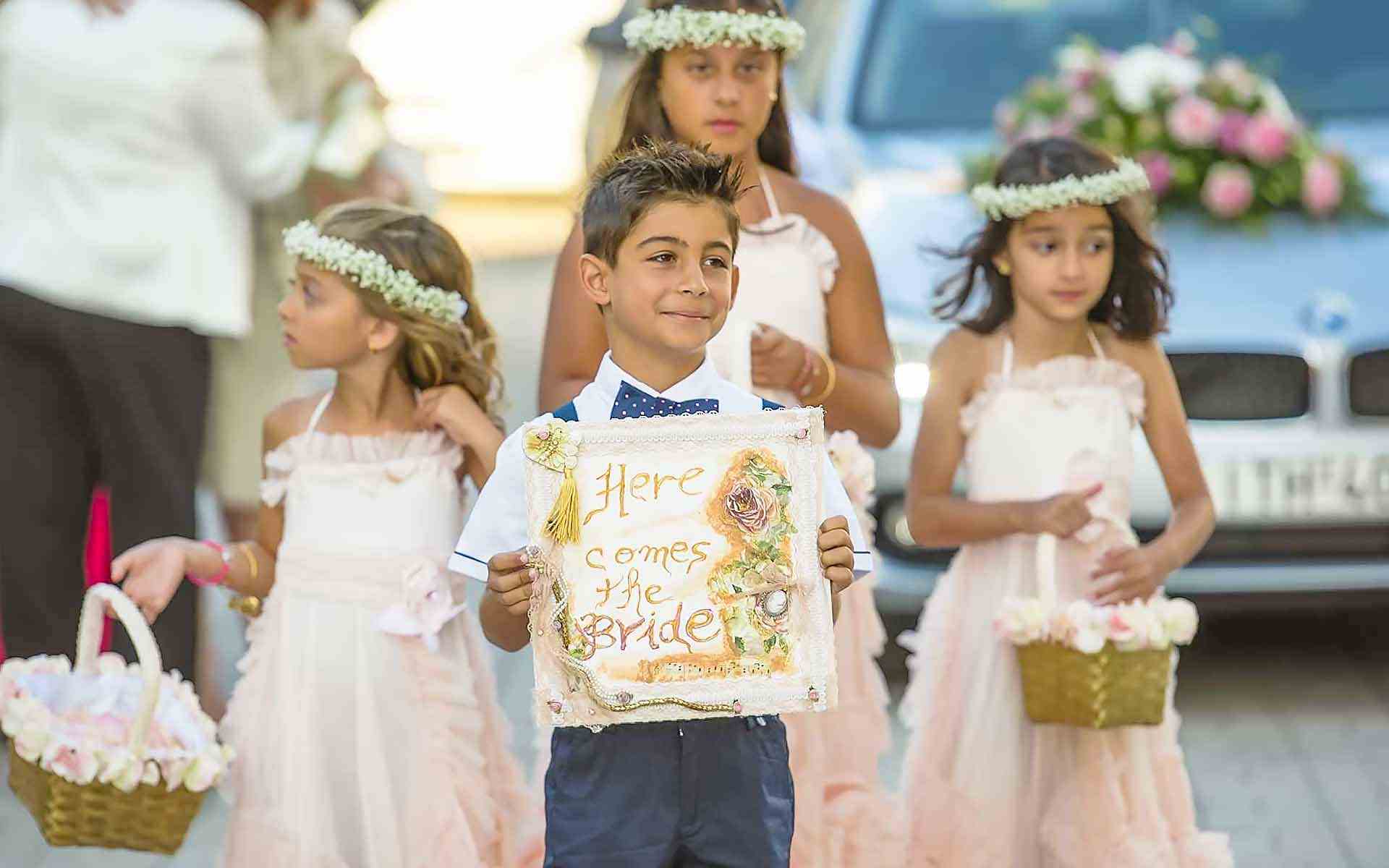 Sweet-Innocence-Ring-Bearer-Boasting-A-Here-Comes-The-Bride-Sign-Flower-Girls-To-Enchant-The-Way-With-Rose-Petals