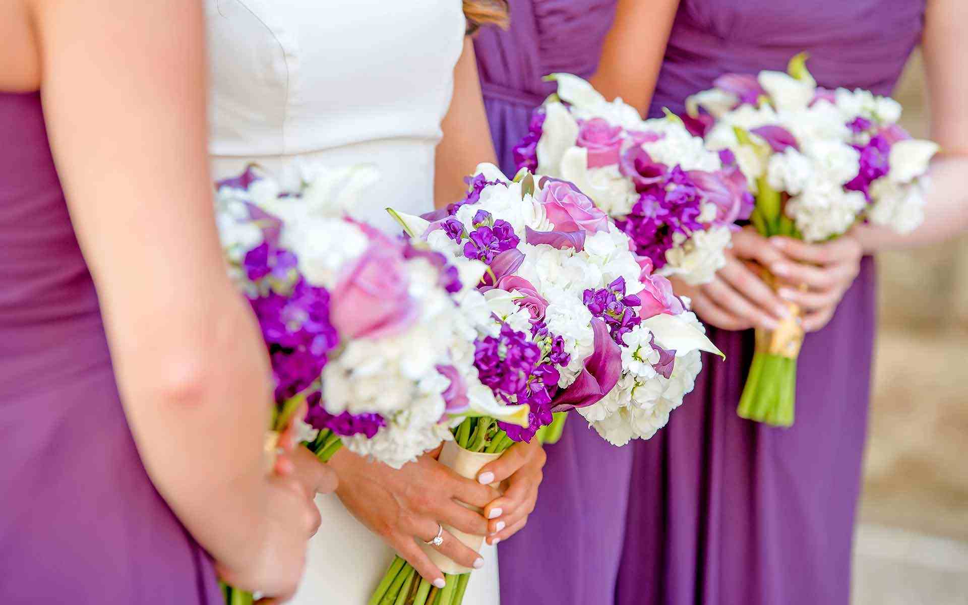 The-Bride-Among-The-Bridesmaids-With-Bouquets-Full-Of-Purple-And-White-Blooms-Popped