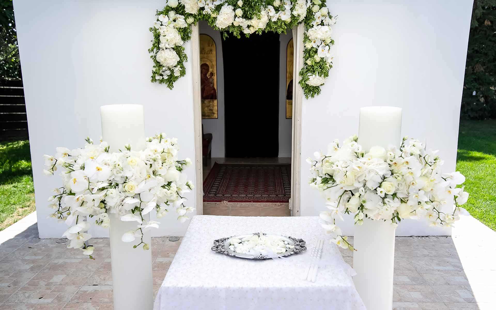 Unity-candle-set-with-Orchids-hydrangeas-and-roses-all-in-white-for-an-Orthodox-ceremony