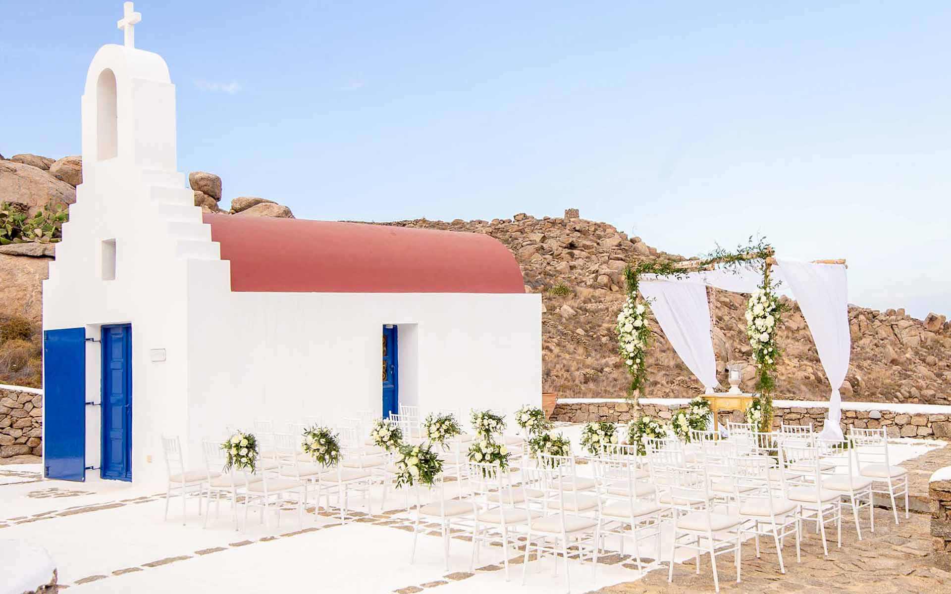 White-seats-on-the-outside-of-a-monastery-on-an-island-of-the-Cyclades-who-are-waiting-for-the-guests-of-the-wedding-ceremony