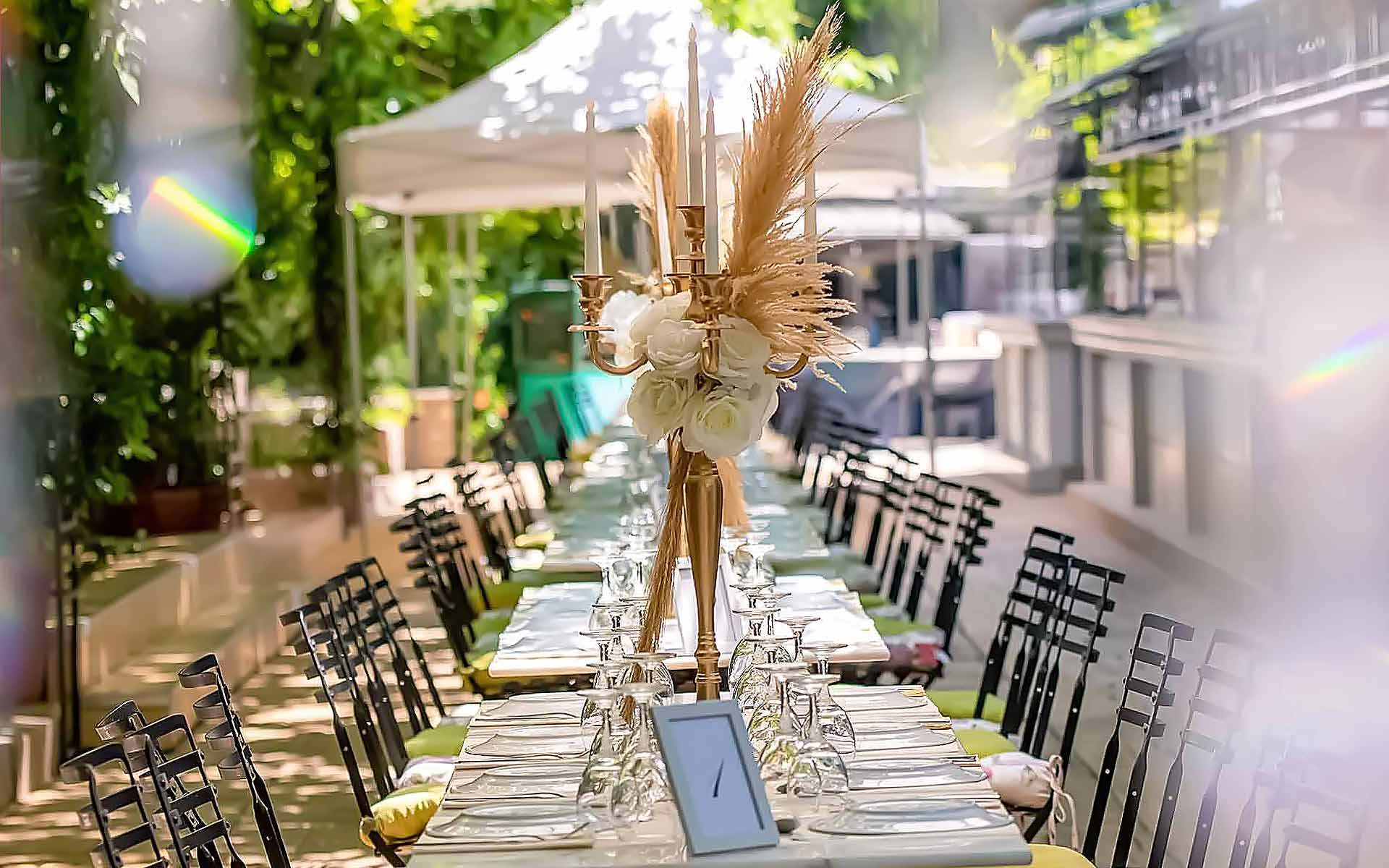 A-tall-gold-candelabra-decorated-with-natural-pampas-grasses-and-white-flowers-as-a-centerpiece-for-each-table-by-Diamond-Events