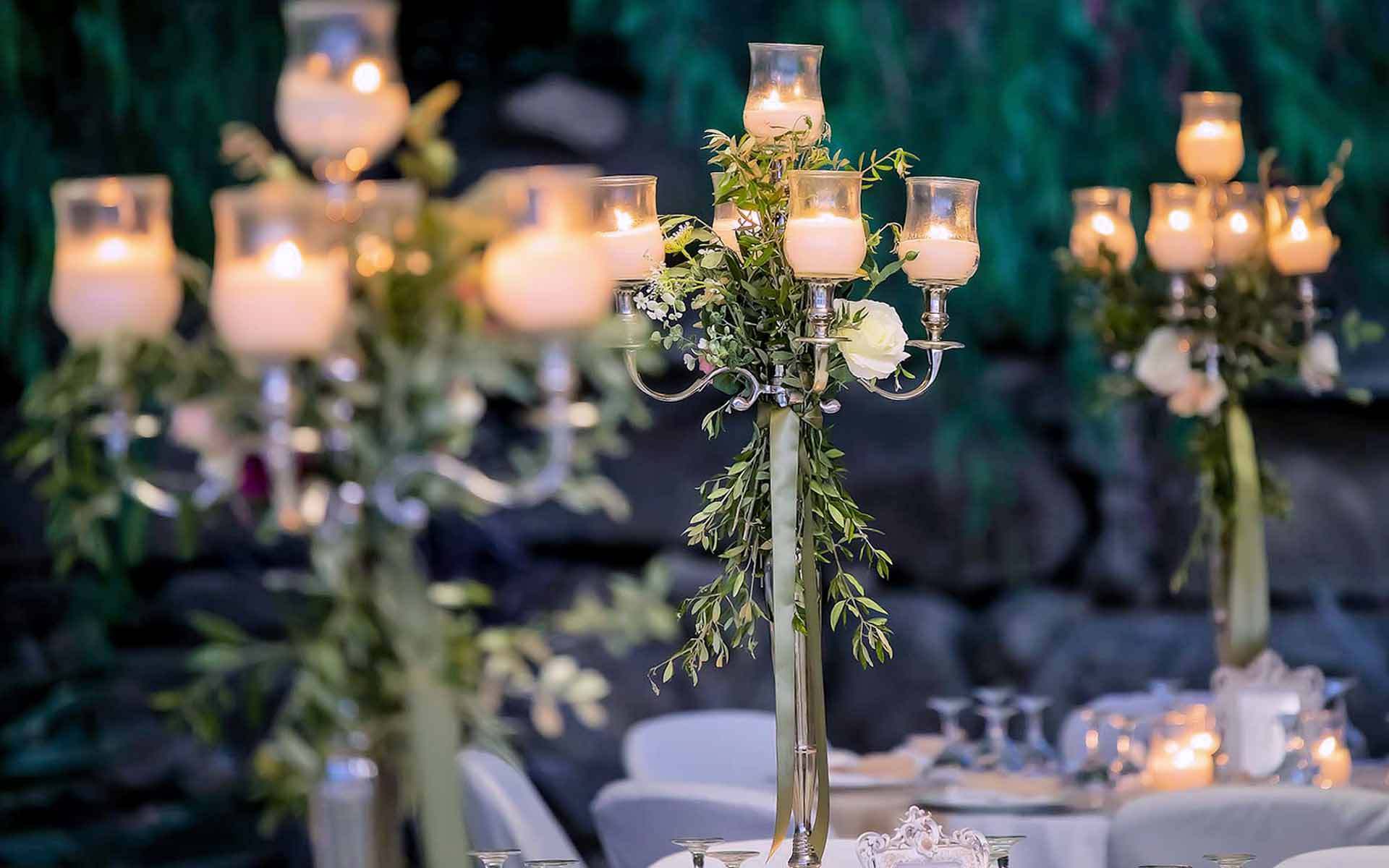 Rustic wedding table decor with candelabras with olive leaf, garland, roses & green ribbons