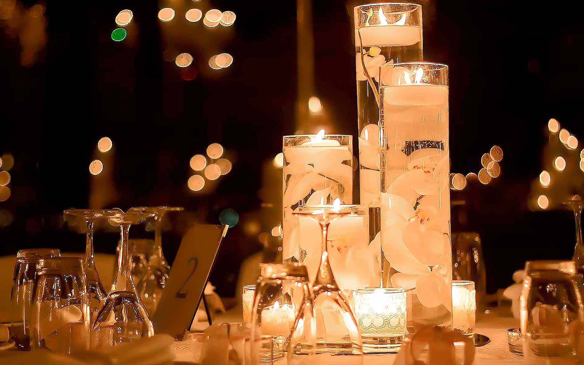 Three cylinder vases with white orchids and candle lighting as centerpiece