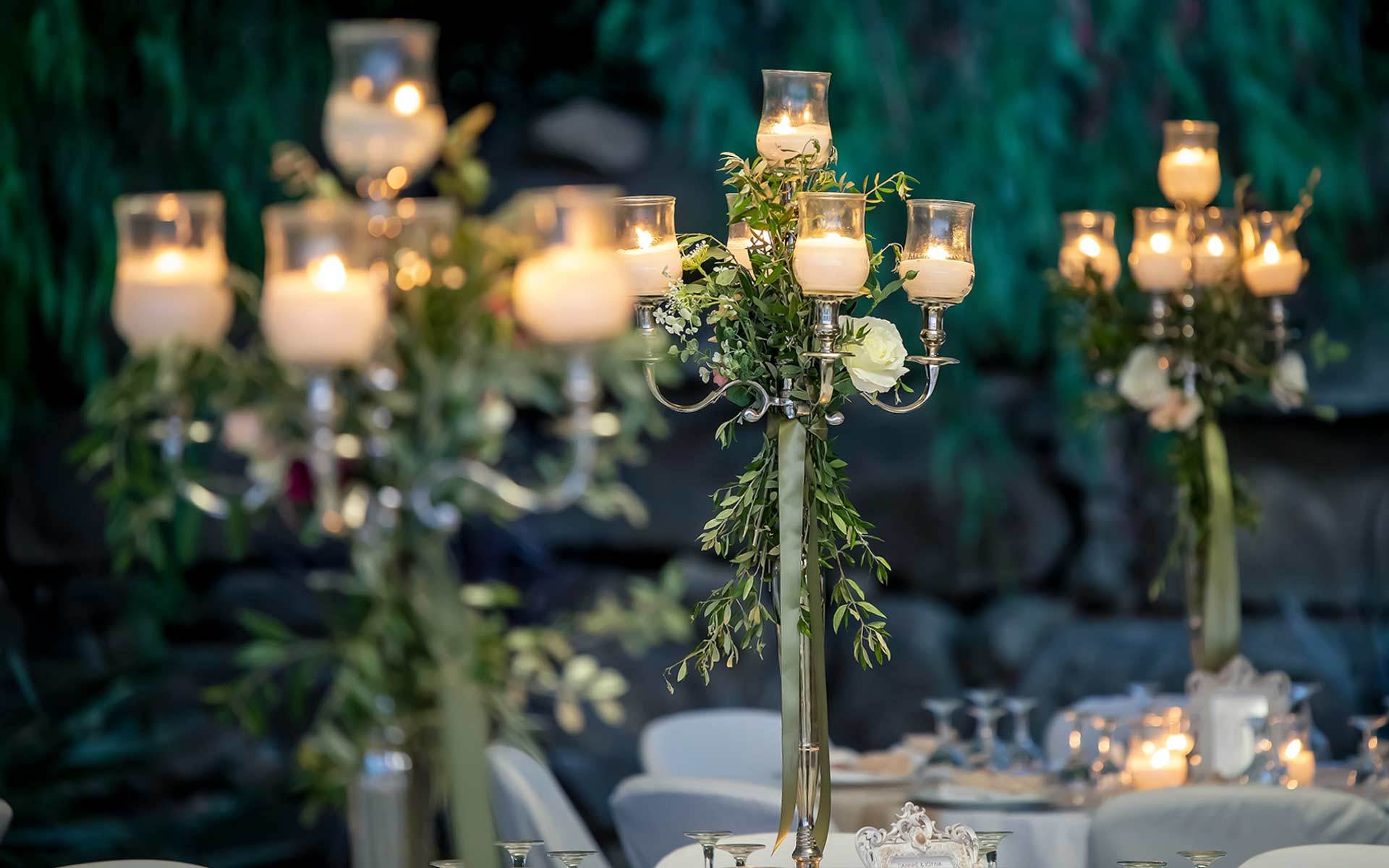 Rustic-wedding-table-decor-with-candelabras-with-olive-leaf-garland-roses-green-ribbons