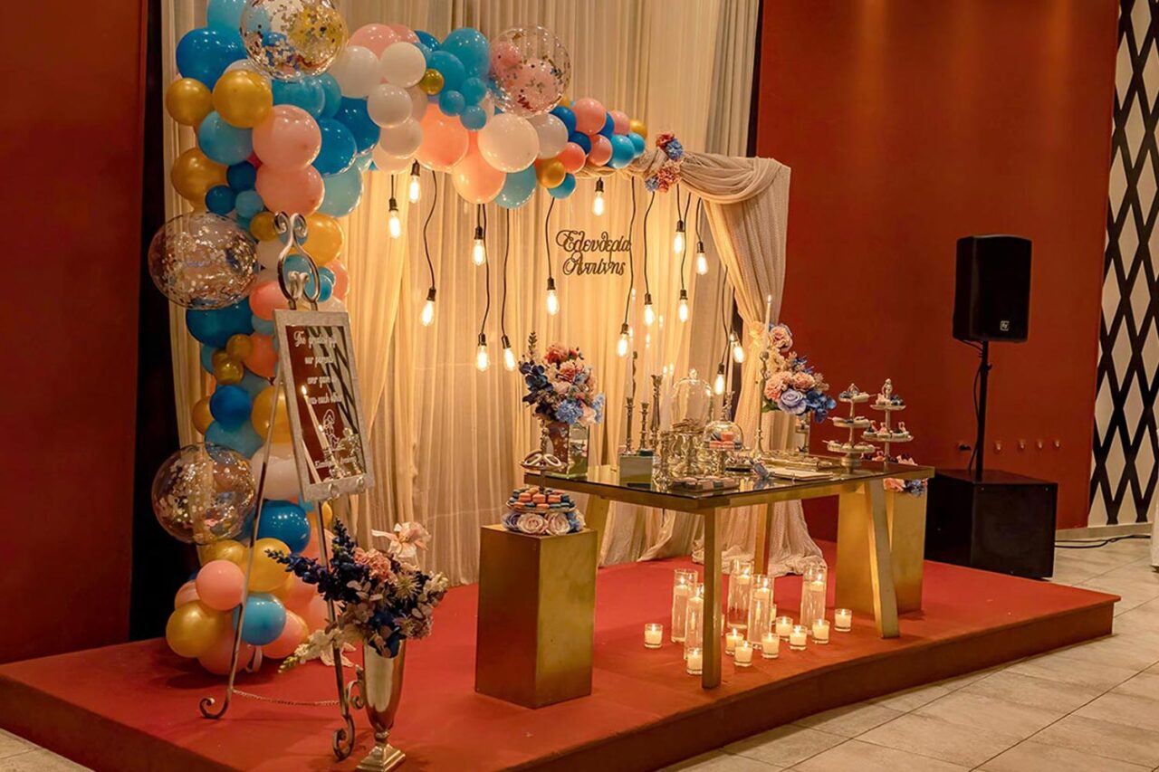 Backdrop elegance — Εντυπωσιακό σκηνικό βάπτισης με χρυσές λεπτομέρειες, μπαλόνια και φωτισμό, υπογραφή Rogdaki Events.