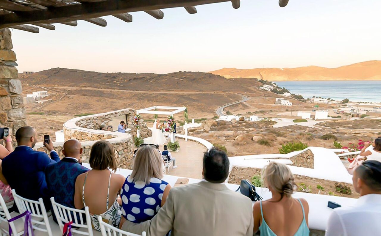Γαμήλιος προορισμός Μύκονος 2 Τελετή στη Μύκονο με φυσικό αμφιθέατρο, ώστε όλοι οι καλεσμένοι να απολαμβάνουν απρόσκοπτα το Μυστήριο και το τοπίο.