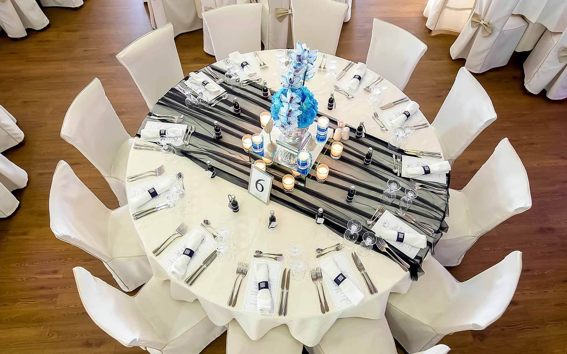 Simple table setting with navy blue runner and blue orchids