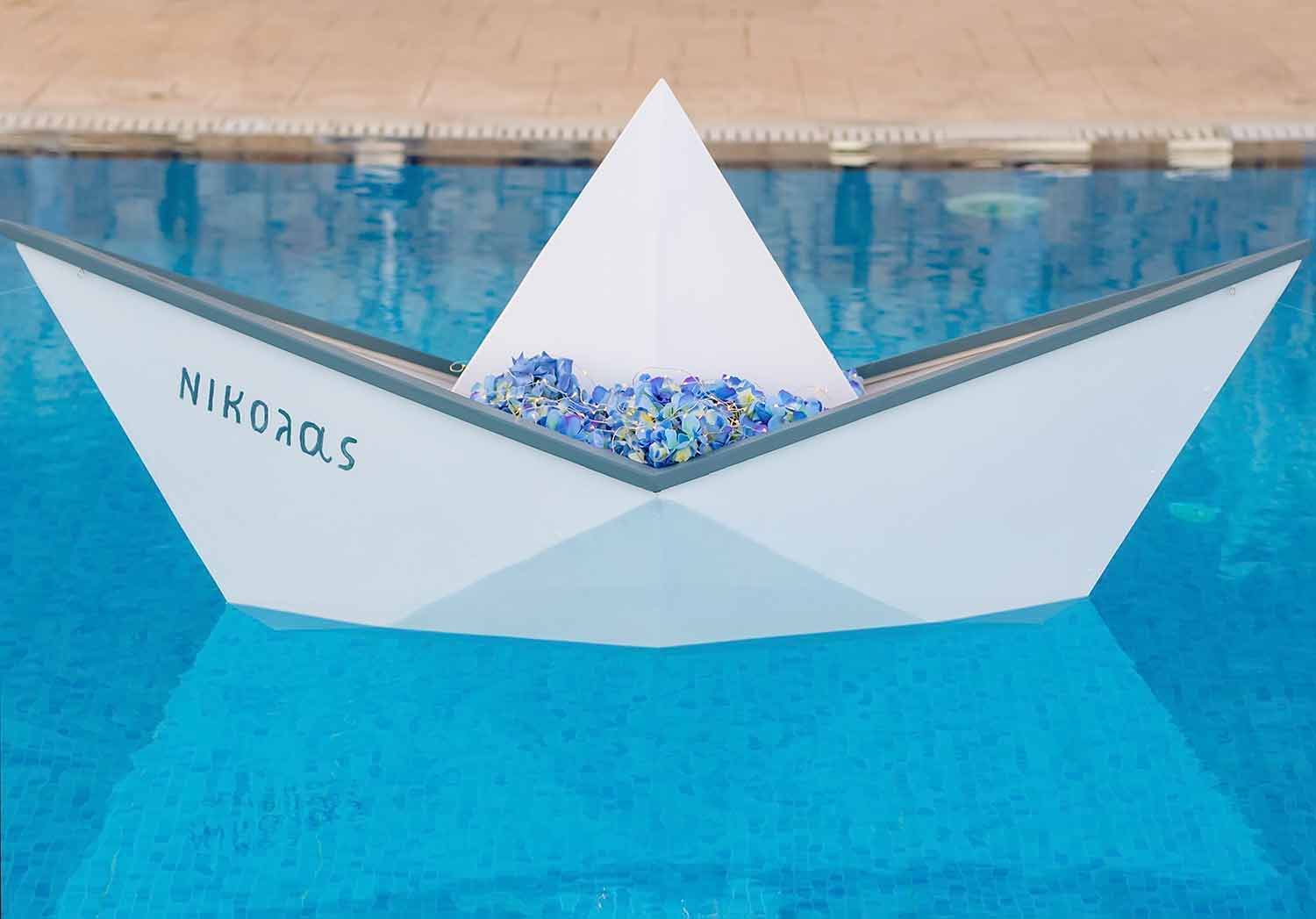 A custom made life size wooden boat named after the nawly baptized baby as a pool dacoration by Diamond Events