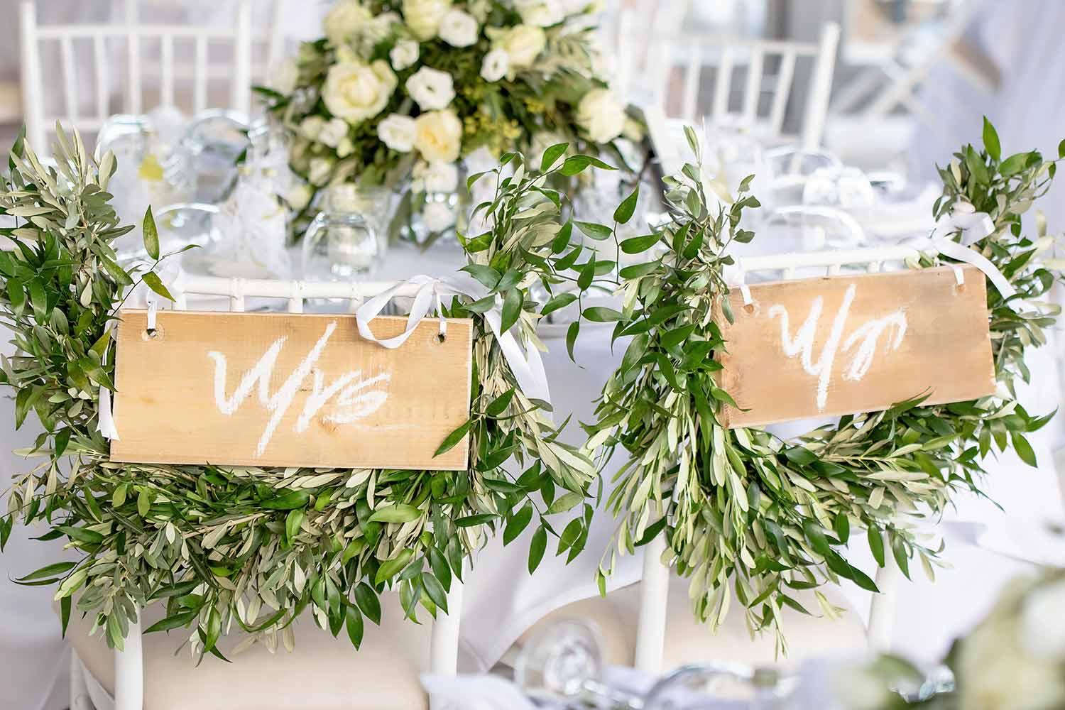 Romantic head table with olive leaves and wooden signs by Diamond Events
