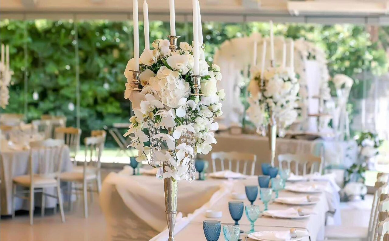 A refined reception layout with silver candelabras and white orchids, expressing Rogdaki Events’ signature high level aesthetic.