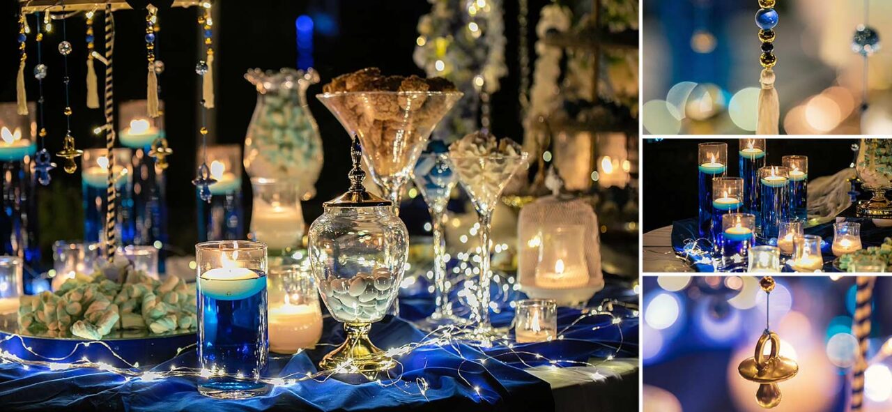 Guestbook table with macaroons blue marshmallows carousel with gold and blue pacifiers fairylights and cylinder vases with colored blue water 1