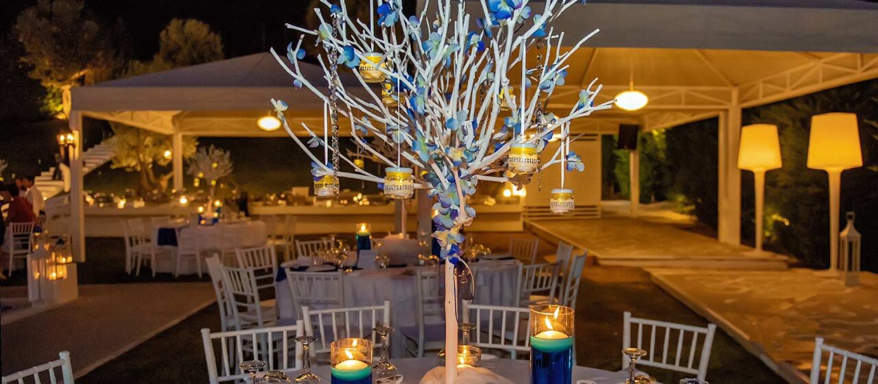 Main centerpiece of the table decoration is a wooden white tree decorated with crystals blue flowers illuminated vases with rhinestones cylinder vases with blue water 1