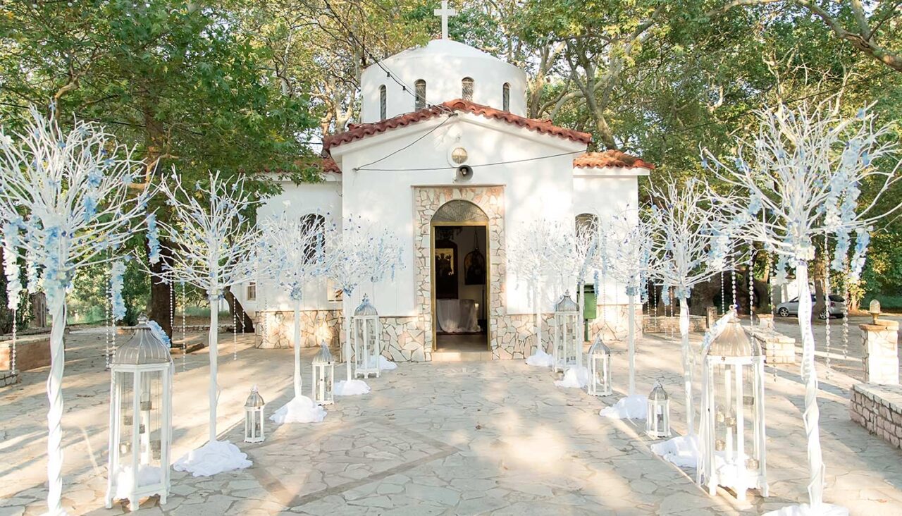 The entrance of the church decorated in a romantic style with white trees light blue flowers and lanterns 1