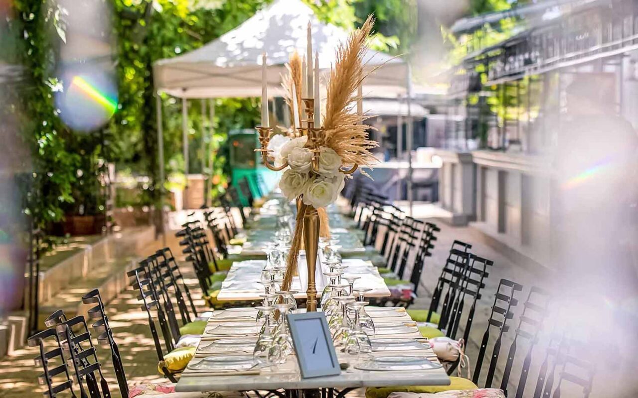 A tall gold candelabra decorated with natural pampas grasses and white flowers as a centerpiece for each table 1