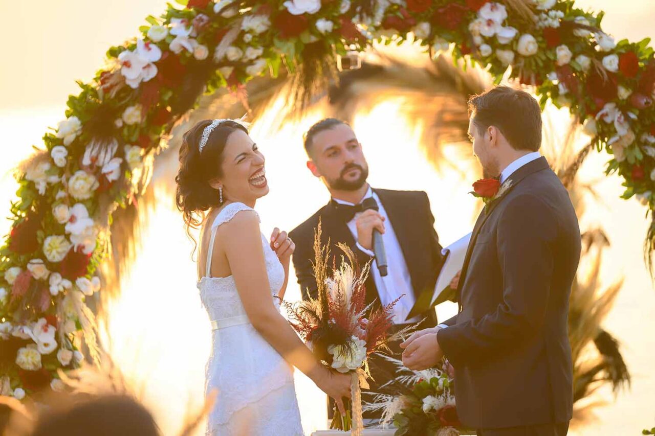07 Bride is happy and laughing during their vows at her Great Gatsby Wedding by Rogdaki Events trademark