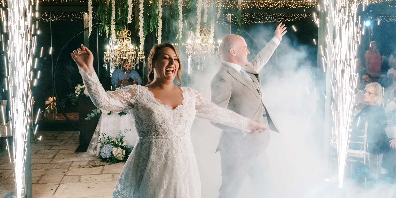 Κεφαλονιά: Ένας Ρομαντικός Γάμος στο Ιόνιο 28 Bride and groom joyfully enter with sparklers. Rogdaki Events created a magical wedding celebration ambiance