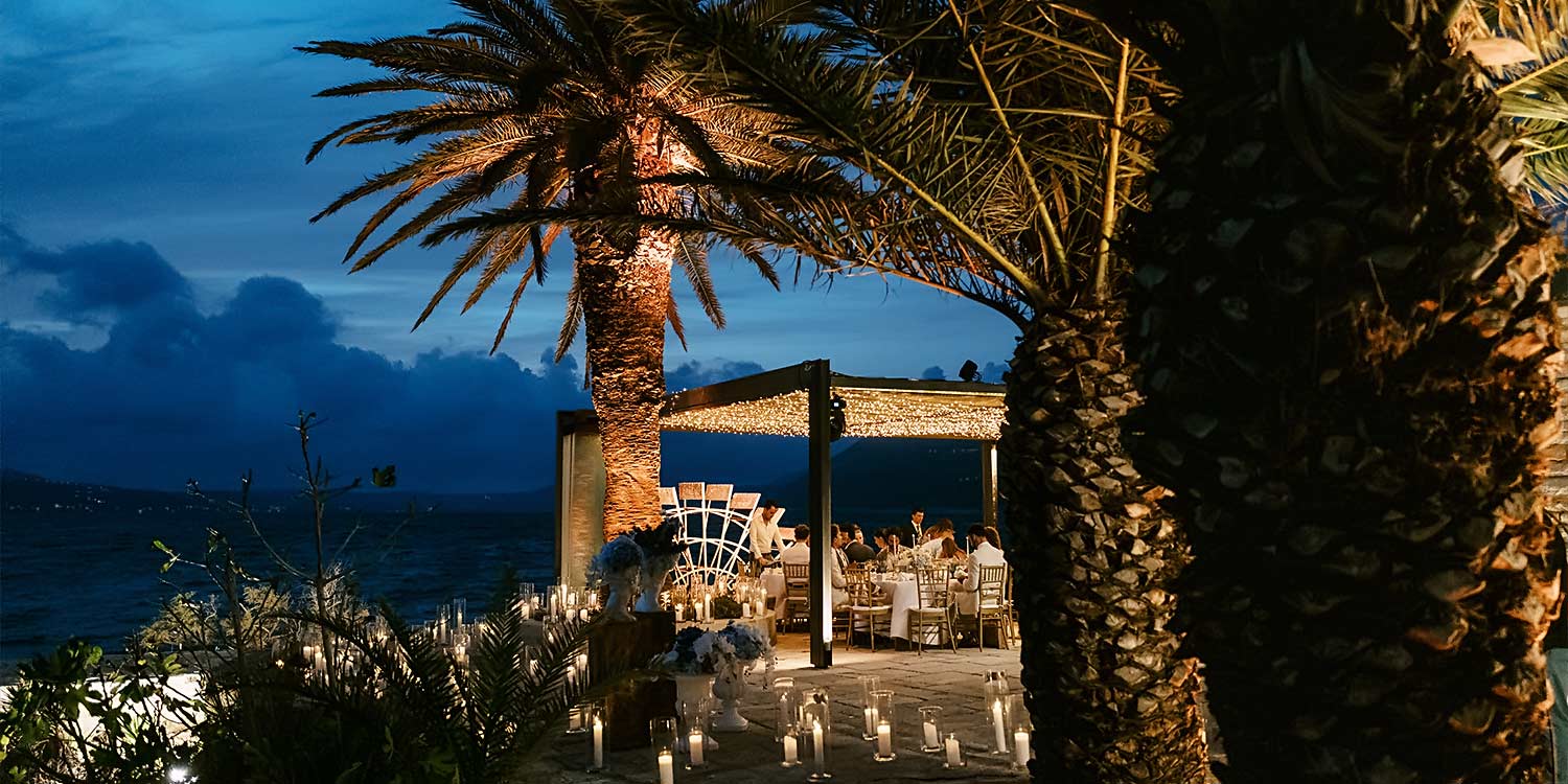 Κεφαλονιά: Ένας Ρομαντικός Γάμος στο Ιόνιο 31 Twilight view of the wedding venue surrounded by candlelight and palm trees. Rogdaki Events created an enchanting atmosphere