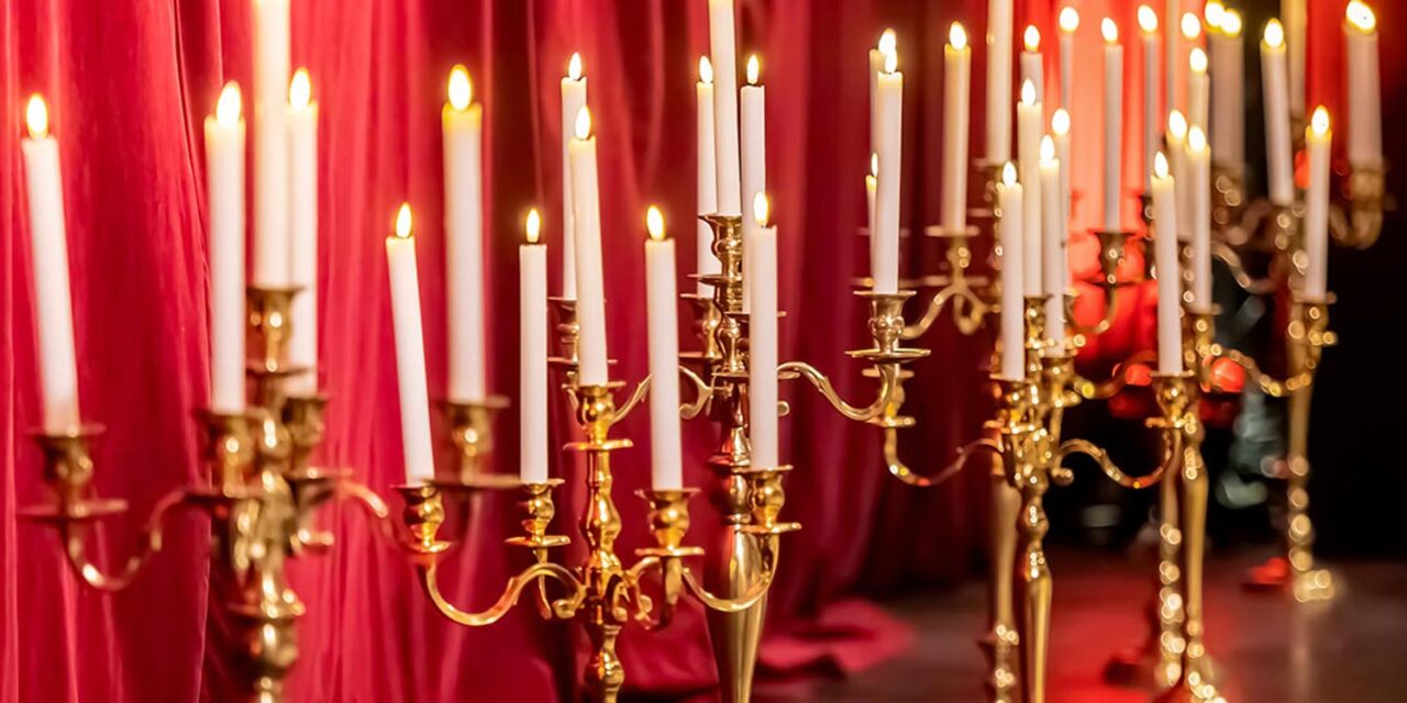 A Miracle Girl Baptism at Royal Theater — velvet curtains, golden candelabras, and flames echo prayers whispered by ancestors