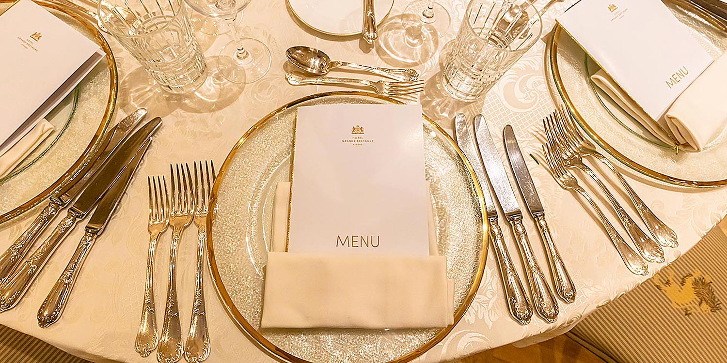 Hotel Grande Bretagne – 150 Χρόνια Ιστορίας 16 Elegant table settings with gold rimmed plates and fine silverware by Rogdaki Events bring timeless sophistication to the Grande Bretagne’s gala dinner and concert
