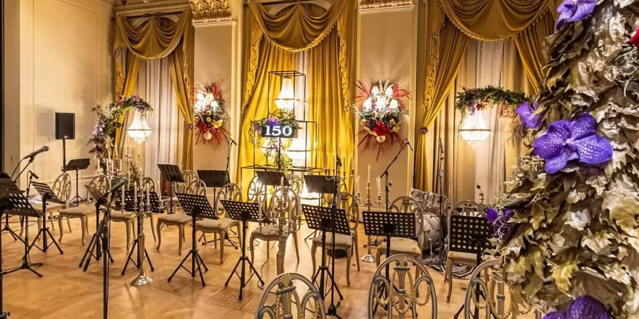 Rogdaki Events designs an elegant concert stage with gold drapery, chandeliers, and festive florals, celebrating 150 years of Grande Bretagne grandeur