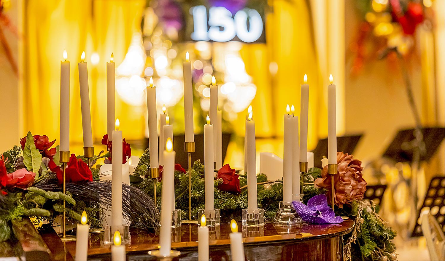 Hotel Grande Bretagne – 150 Χρόνια Ιστορίας 8 Rogdaki Events enhances the piano with glowing candles and roses, framing the illuminated “150” centerpiece in a romantic golden atmosphere for the Grande Bretagne gala