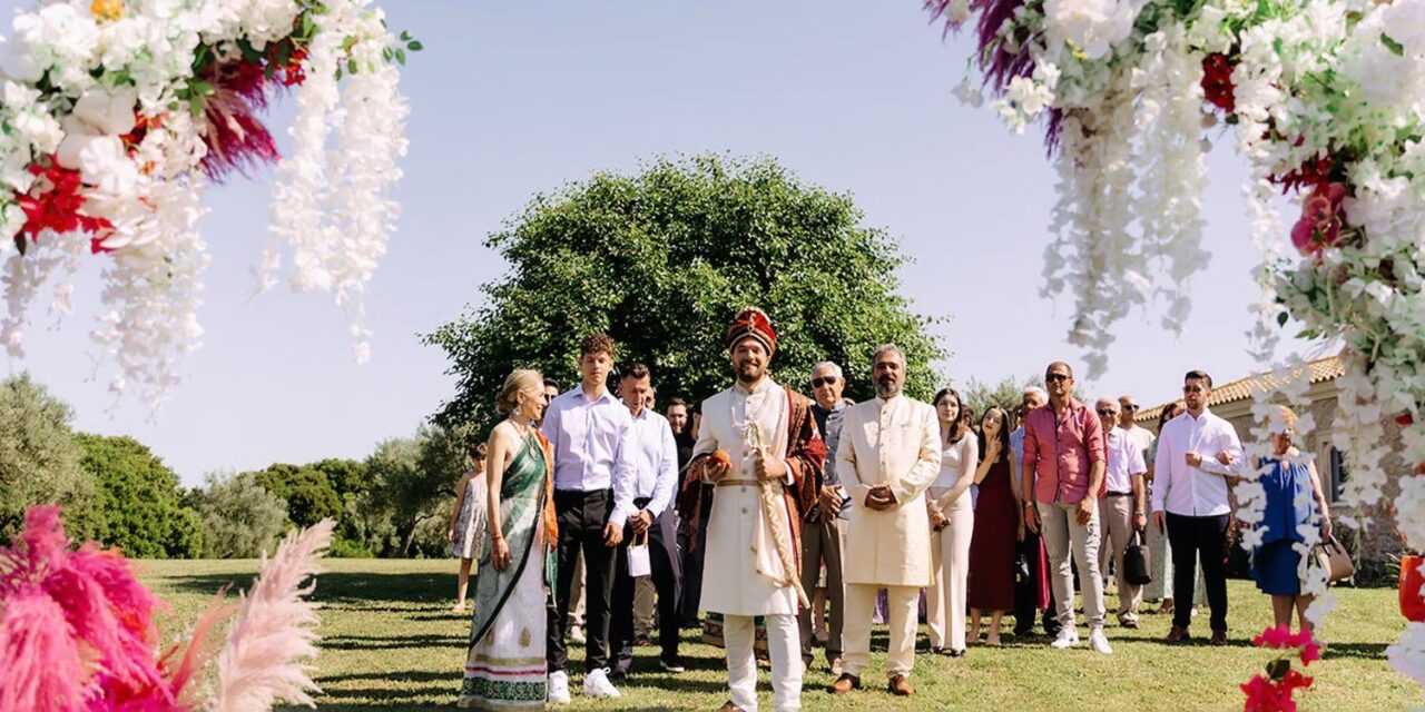 Indian Wedding in a Private Villa, by Rogdaki Events — the groom stands confidently under floral arches, surrounded by family and friends, ready for the grand ceremony