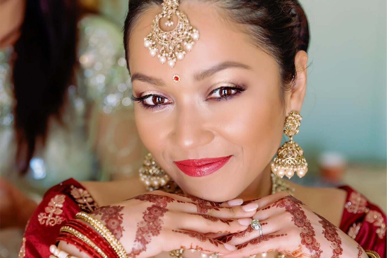 Indian Wedding in a Private Villa, by Rogdaki Events — the radiant bride shines with elegance, adorned in gold jewelry, henna, and a graceful bridal smile