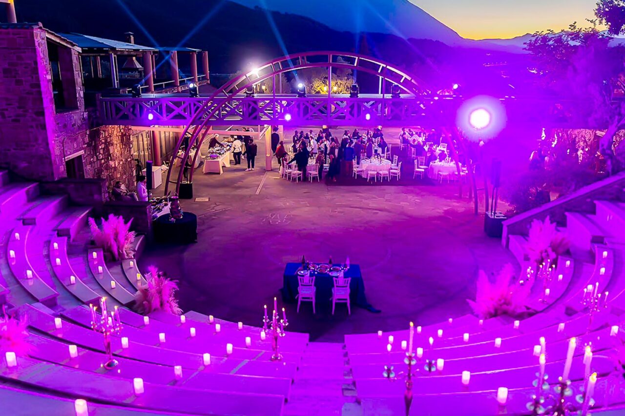 Romantic twilight view of the amphitheater and terrace lit in purple, setting the stage for an Ancient Greek Wedding in an Amphitheater by Rogdaki Events