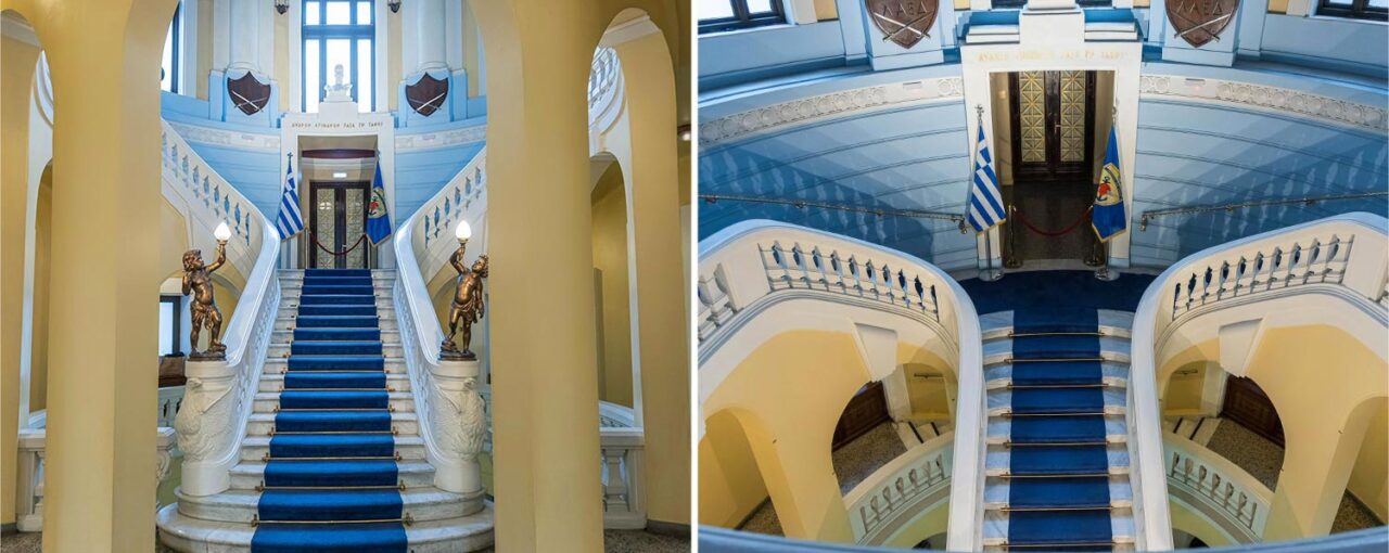 Majestic marble staircases with deep blue carpets rise beneath elegant arches and soft yellow walls