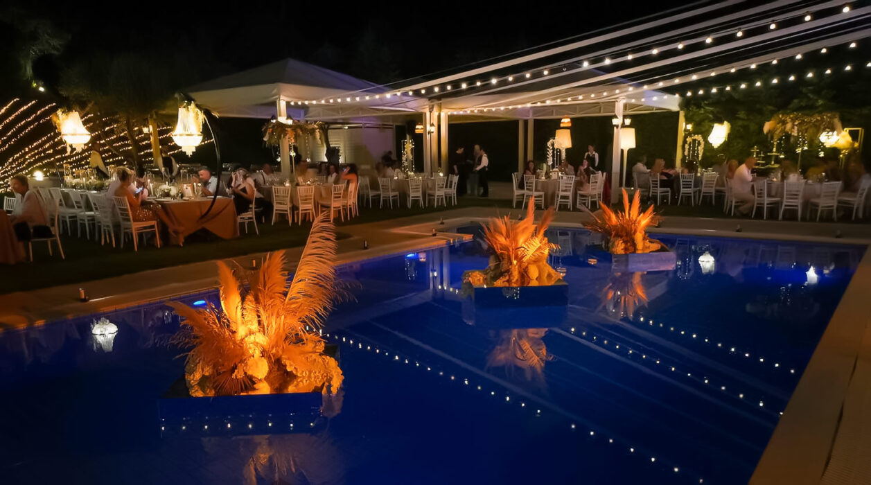 Ορθόδοξος, Πολυτελής Γάμος στο Ηδύλοφον 29 Poolside reception, dim lighting, and illuminated floral installations in the water
