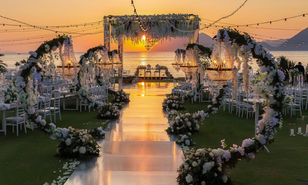 Breathtaking seaside setup with chandeliers and blooms at a Luxury Seaside Wedding in Greece by Rogdaki Events