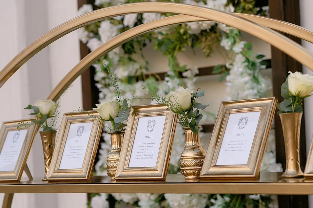 Elegant seating chart in golden frames, designed by Rogdaki Events for a Luxury Seaside Wedding in Greece