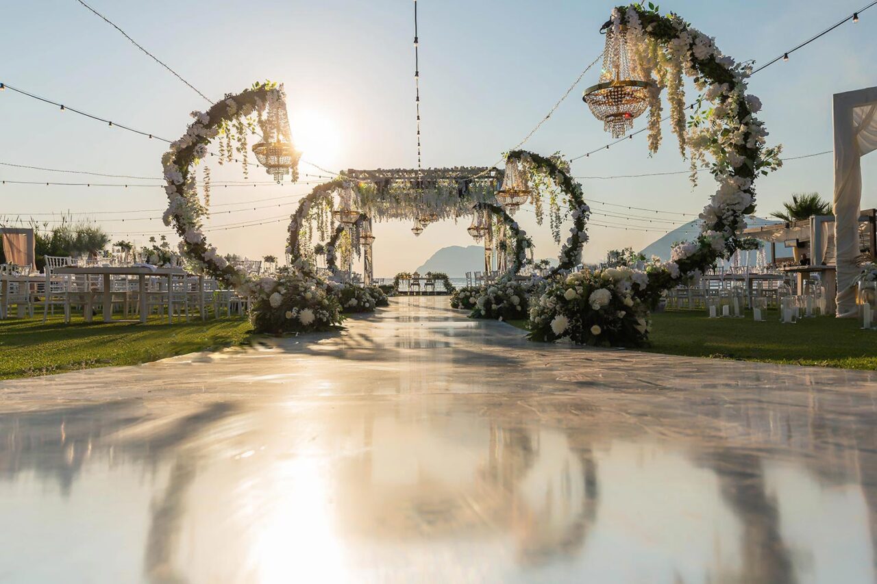 Golden hour reflections on the aisle at a Luxury Seaside Wedding in Greece, masterfully arranged by Rogdaki Events