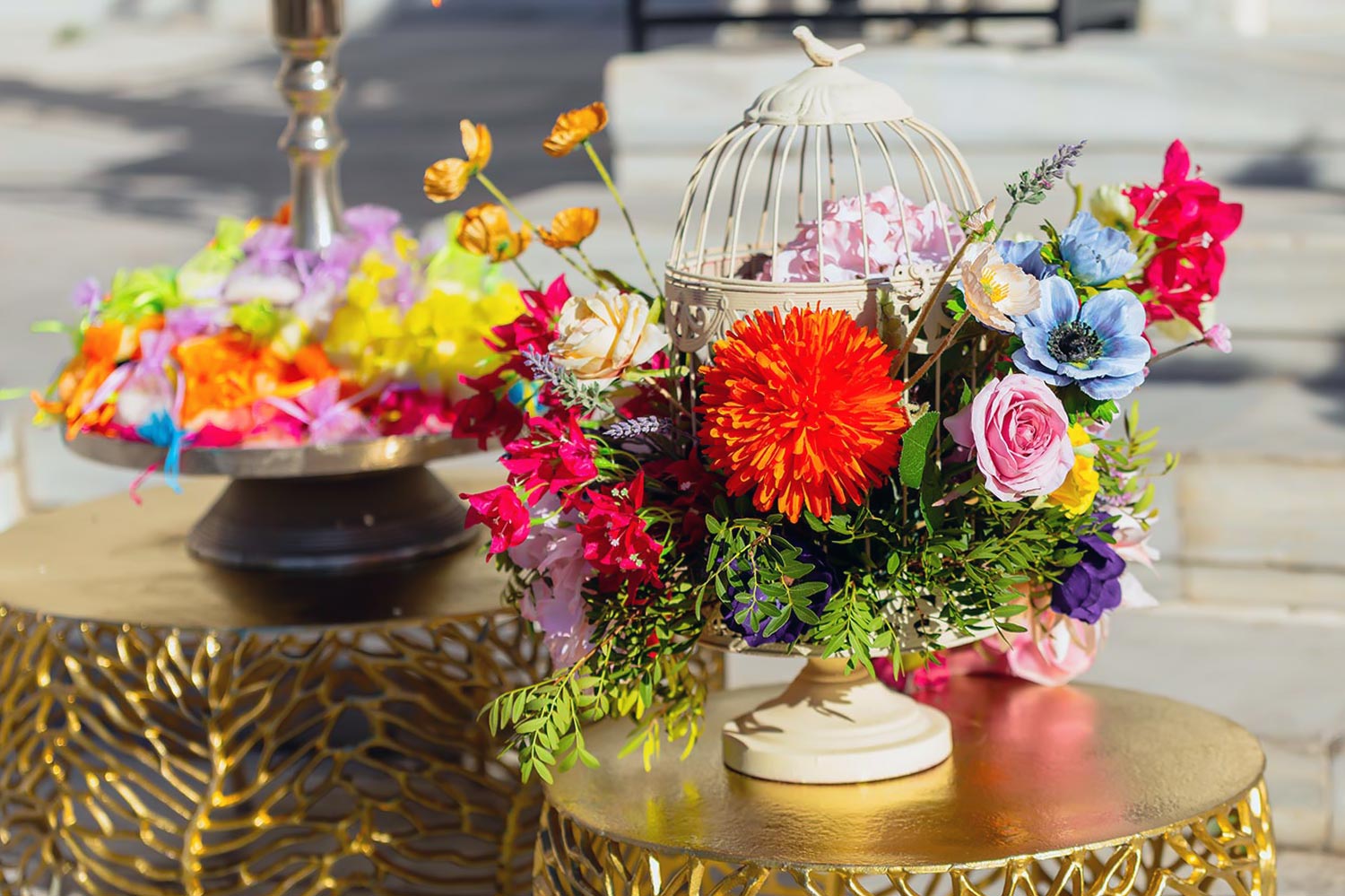 Chic & Colorful Γάμος στο Κτήμα Παναγιωτόπουλου 16 Rogdaki Events, Μια σύνθεση σε κλουβί πάνω σε χρυσό τραπέζι, αποτυπώνοντας την ουσία ενός πολύχρωμου γάμου.