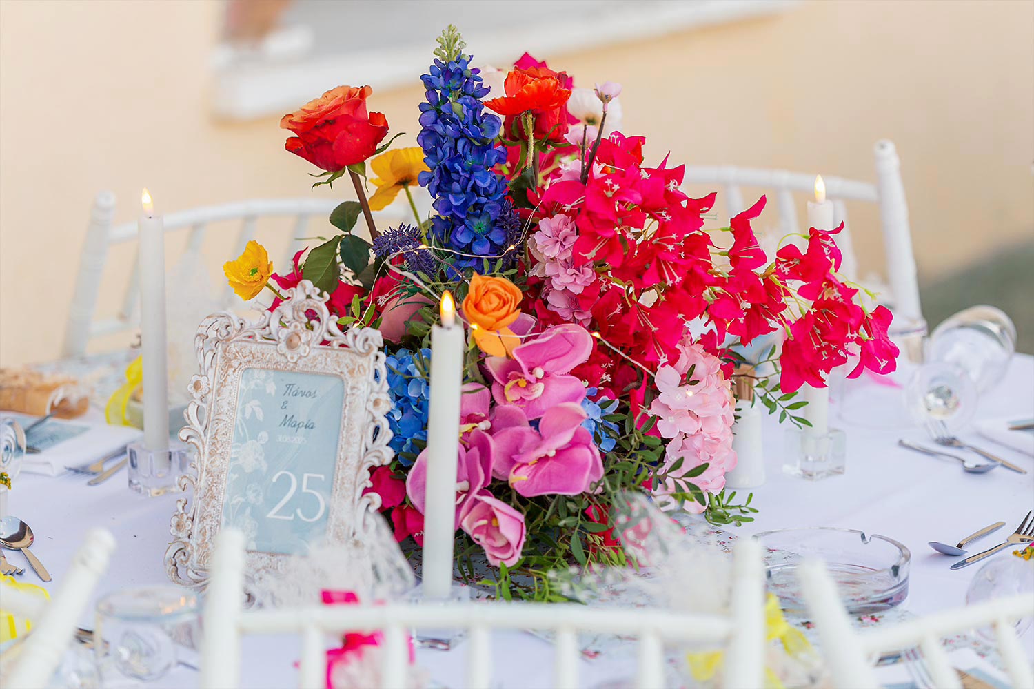 Chic & Colorful Γάμος στο Κτήμα Παναγιωτόπουλου 24 Rogdaki Events, κοντινό πλάνο γιορτινού τραπεζιού με μια ρομαντική ανθοσύνθεση