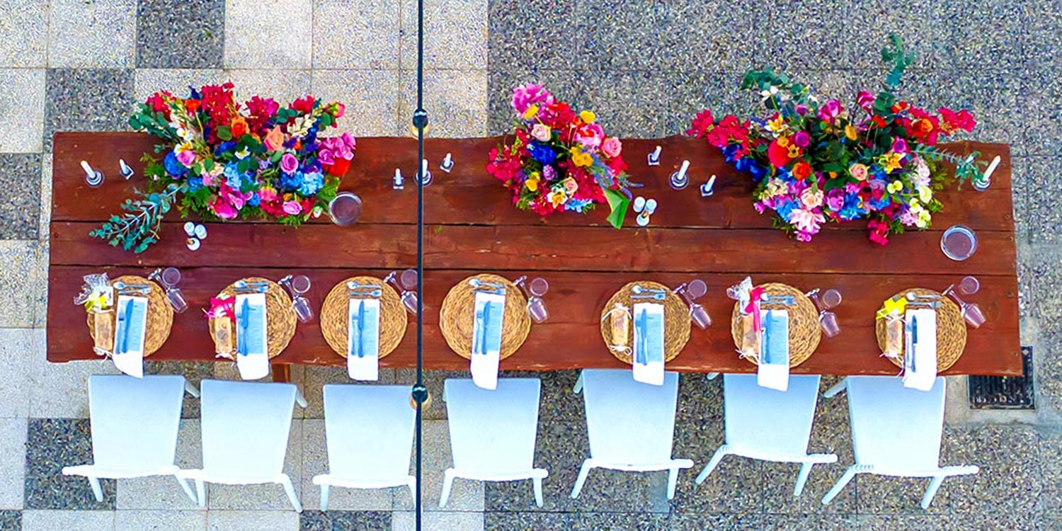 Chic & Colorful Γάμος στο Κτήμα Παναγιωτόπουλου 26 Rogdaki Events, μια εναέρια προοπτική του μακρόστενου ξύλινου νυφικού τραπεζιού στο Κτήμα Παναγιωτόπουλου