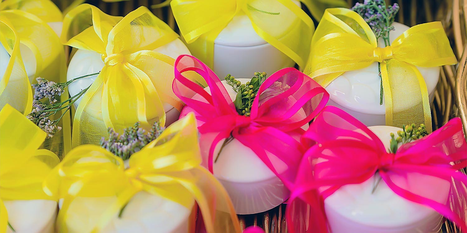 Chic & Colorful Γάμος στο Κτήμα Παναγιωτόπουλου 32 Rogdaki Events, μπομπονιέρες με έντονες κίτρινες και φούξια κορδέλες, διακοσμημένες με λεπτά αποξηραμένα λουλούδια μέσα σε καλάθι.