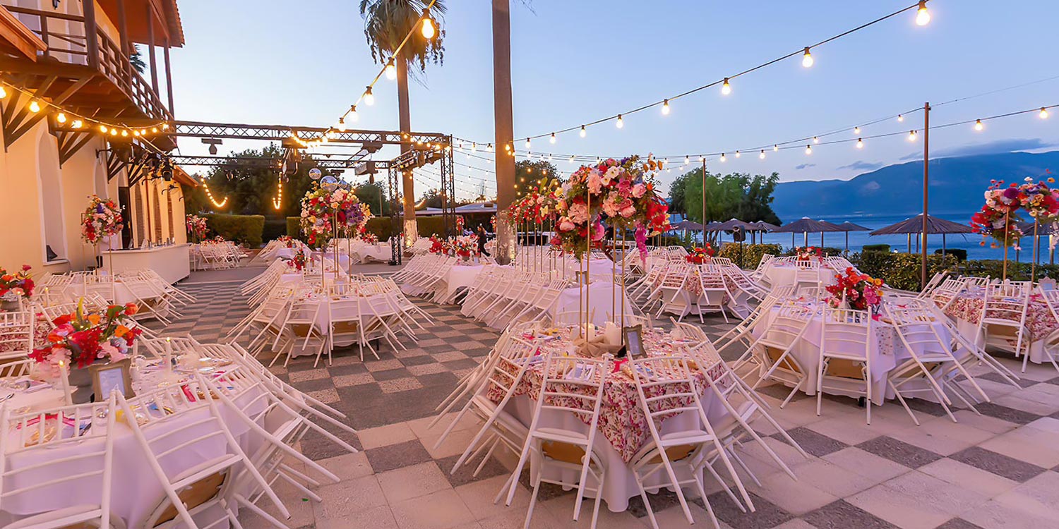 Chic & Colorful Γάμος στο Κτήμα Παναγιωτόπουλου 40 Rogdaki Events, το Κτήμα Παναγιωτόπουλου με λευκά τραπέζια, ψηλές συνθέσεις λουλουδιών και ζεστό ατμοσφαιρικό φωτισμό.