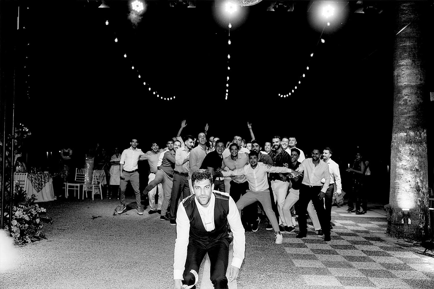 Chic & Colorful Γάμος στο Κτήμα Παναγιωτόπουλου 52 Rogdaki Events. Ατμοσφαιρική ασπρόμαυρη λήψη του γαμπρού και φίλων που διασκεδάζουν στην πίστα του χορού.