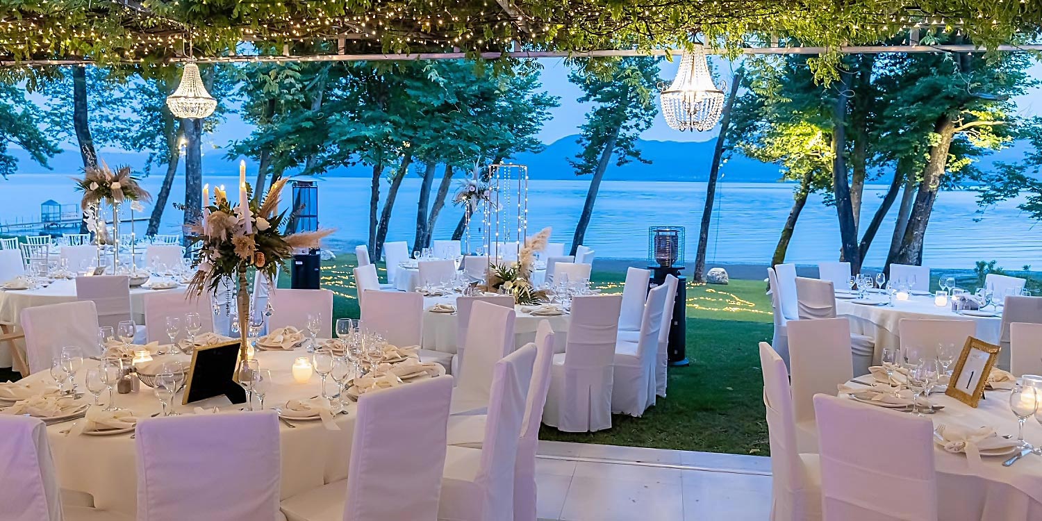 Trichonida Lake Wedding 28 A lakeside wedding organized by Rogdaki Events at Pithari, featuring elegant white decor and hanging chandeliers by the water