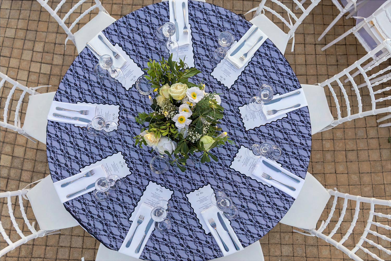 Art de la table από τη Rogdaki Events, Στρογγυλό τραπέζι με μαύρη δαντέλα, λευκές ανθοσυνθέσεις και κομψό μενού δεξίωσης