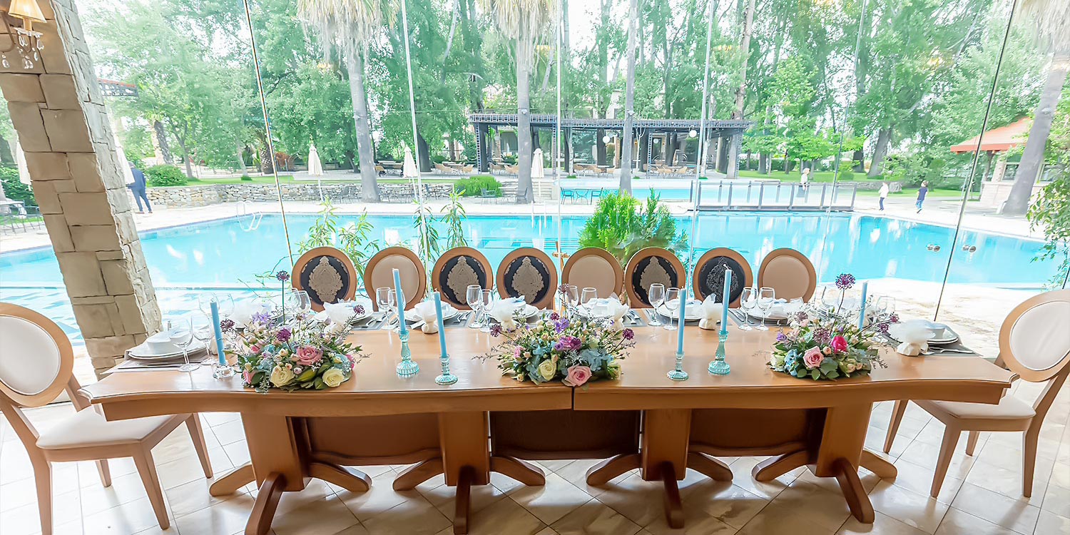 A Signature Wedding & Baptism Production in Blue 14 Decorated table at Korali, Agrinio, by Rogdaki Events with a poolside view for an impressive wedding.