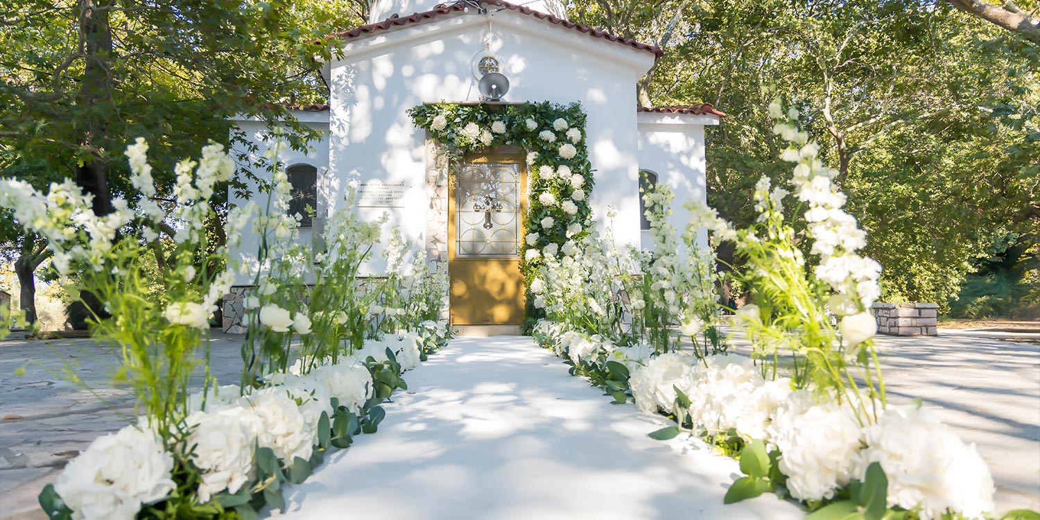 Ελληνικο-Γαλλικός Σικάτος Γάμος 3 Λευκή, ανθοστολισμένη διαδρομή προς τον Άγιο Αναστάσιο Δρεπάνου, σχεδιασμένη από τη Rogdaki Events