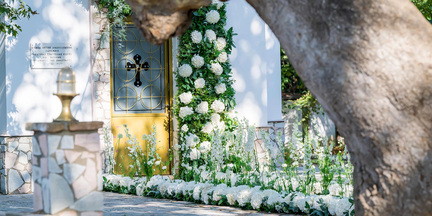 Ελληνικο-Γαλλικός Σικάτος Γάμος 4 Πέτρινη είσοδος του Αγίου Αναστασίου Δρεπάνου με χρυσή πόρτα και γιρλάντα, διακόσμηση Rogdaki Events