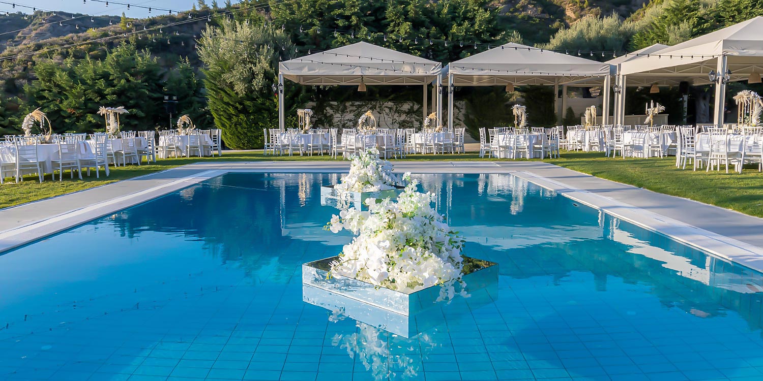 Greek‑French Chic Wedding 12 Rogdaki Events planned this layout at Idilofon, featuring elegant poolside floral arrangements.