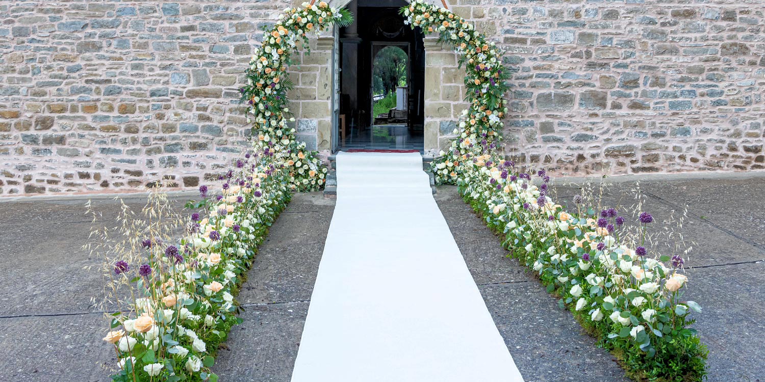 Trichonida Lake Wedding 3 Rogdaki Events styled this elegant ceremony entrance in agrinio with lush florals and timeless sophistication