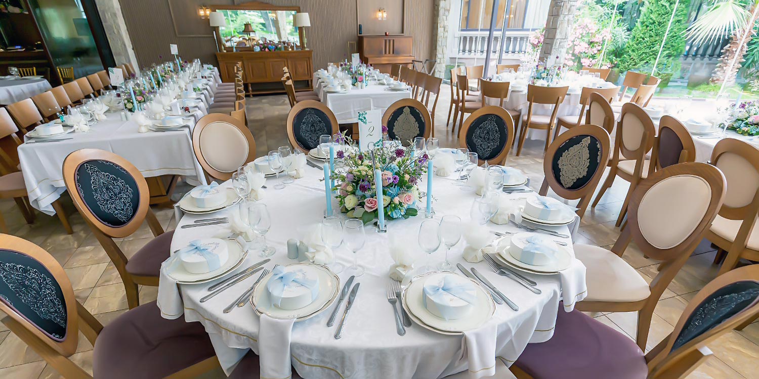 A Signature Wedding & Baptism Production in Blue 26 Wedding reception hall at Korali, Agrinio, by Rogdaki Events, featuring set round tables and a poolside view.