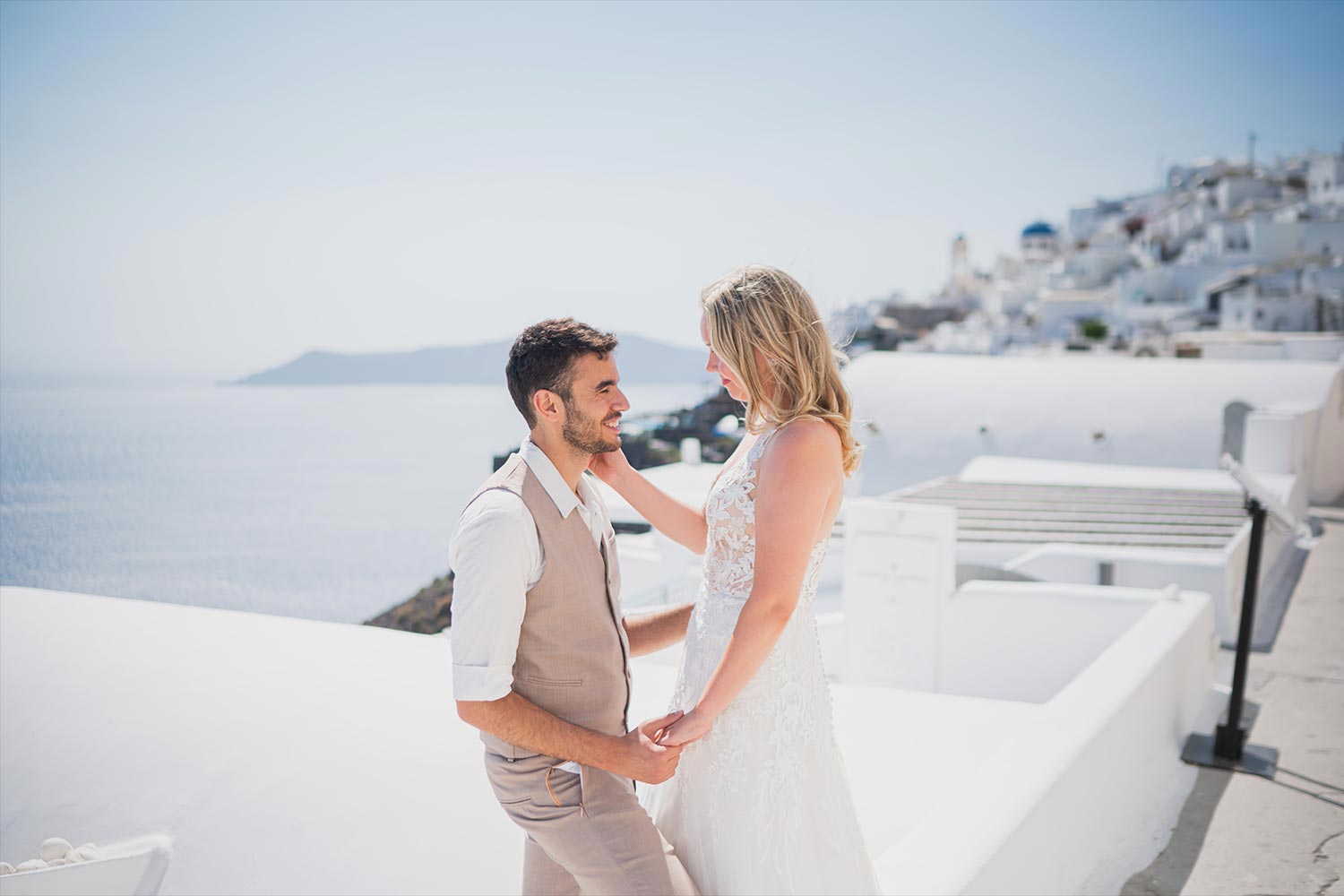 Γάμος σε Ταβέρνα στη Σαντορίνη 11 Γάμος στη Σαντορίνη με Rogdaki Events ρομαντικές πόζες με φόντο τρούλους και Αιγαίο