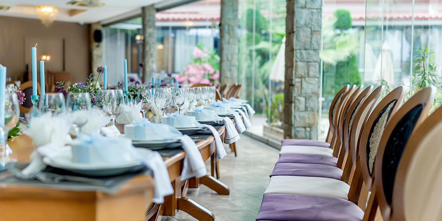 Γάμος και βάπτιση στο Αγρίνιο με μοντέρνο ύφος 32 Γάμος στο Κοράλι, Αγρίνιο από Rogdaki Events με φωτεινό, κομψό στήσιμο τραπεζιού, μπλε κεριά και ανθοσυνθέσεις σε μωβ και λευκό.